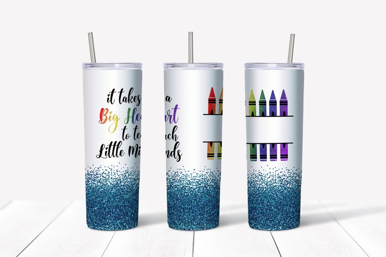May include: Three stainless steel tumblers with lids and straws. The tumbler on the left has a blue glitter bottom and says "It takes a Big Heart to teach Little Minds". The middle tumbler has a rainbow of crayons and the text "A Heart to Teach Little Minds". The tumbler on the right has a row of rainbow crayons.