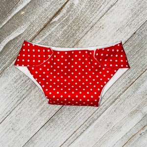 May include: Red and white polka dot diaper with white trim.