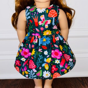 May include: A sleeveless green dress with a floral and mushroom print. The dress has a fitted bodice and a full skirt.