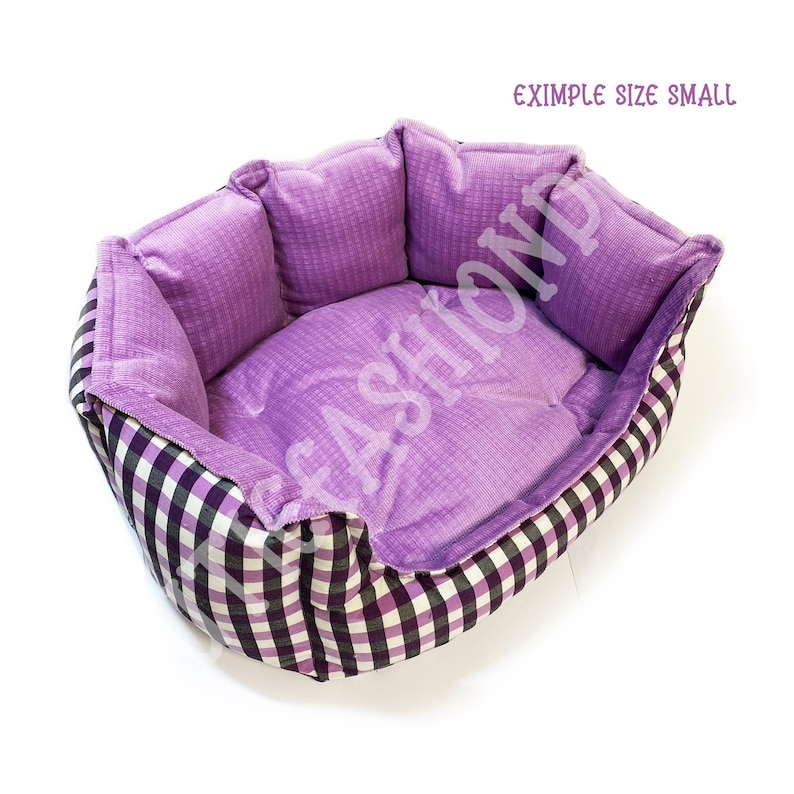 May include: Purple and white checkered dog bed with a soft purple lining. The bed is shaped like a donut and has a raised edge. "EXIMPLE SIZE SMALL" is written on the white background.