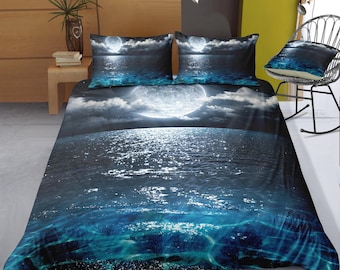 May include: A blue and white bedding set with a moon and ocean design. The bedding features a dark blue background with white clouds and a large, bright moon reflecting on the ocean waves.