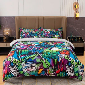 May include: A colourful duvet cover with a graffiti-style design featuring musical notes, a boombox, a guitar, and the words "Life is Music" and "Bigger is Cool".