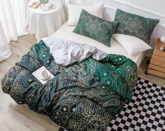 Könnte beinhalten: Ein grüner und goldener Mandala-Muster-Bettbezug mit zwei passenden Kissenbezügen. Der Bettbezug liegt auf einem weißen Bett mit einem weißen Nachttisch und einer Blumenvase.
