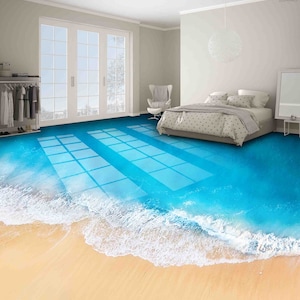 Könnte beinhalten: Ein Schlafzimmer mit einem Bett und einem weißen Deckenventilator. Der Boden ist eine 3D-optische Täuschung eines Strandes mit blauem Wasser und weißen Wellen.