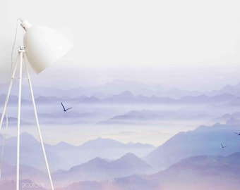 May include: A white tripod floor lamp with a large, angled shade stands before a misty mountain landscape. The mountains are a gradient of blues and purples, with birds in flight. The image has a soft, serene aesthetic.