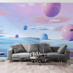 May include: A grey sofa with two matching throw pillows and a black and white patterned throw blanket, positioned in front of a wall mural featuring a surreal landscape with large pink and blue spheres floating above a blue horizon.