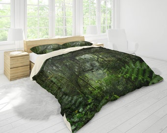 May include: A green and brown duvet cover with a forest scene featuring trees, ferns, and foliage. The duvet cover is on a bed with white sheets and pillows.