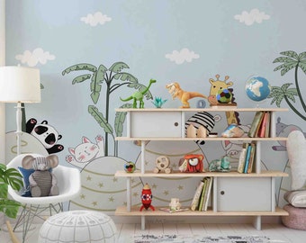 Puede incluir: Una silla mecedora blanca con un elefante de peluche gris sentado en ella. Un puf blanco se encuentra delante de la silla. Una estantería con juguetes y libros se encuentra contra una pared azul claro con un mural de jungla de dibujos animados. El mural presenta un panda, un gato, una jirafa, un dinosaurio y palmeras.