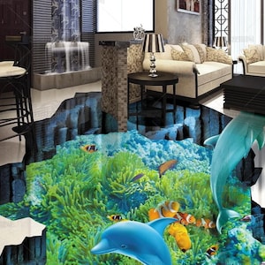 May include: A 3D floor mural featuring an underwater scene with vibrant green coral reefs, orange and white clownfish, and two blue dolphins swimming through a deep crevice in the floor, creating an illusion of a hole opening into the ocean.
