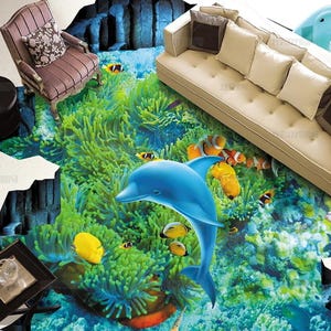 May include: A large floor mural featuring a 3D underwater scene with a bright blue dolphin, vibrant green sea anemones, and various tropical fish including clownfish and yellow tangs, set against a deep blue ocean floor with rocky formations.