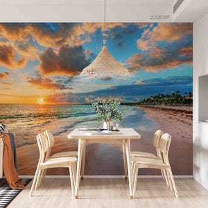 May include: A scenic wall mural depicting a beach at sunset with a vibrant sky of orange, blue, and white clouds. A small wooden table and chairs are in front of the mural. A woven pendant light hangs from the ceiling.