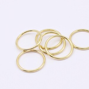 May include: A set of six gold-colored metal rings of varying sizes. The rings are smooth and have a polished finish.