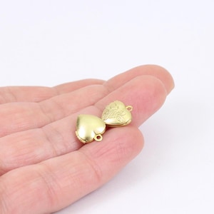 May include: Two gold heart-shaped locket charms featuring a floral design. The lockets are open and ready to be filled with a special message or small trinket.