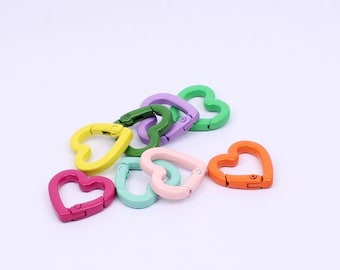 May include: A set of colorful heart-shaped metal clasps. The clasps are in various colors, including green, yellow, pink, orange, and purple.