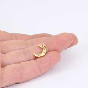 May include: Gold crescent moon charm with small clear crystals set into the surface.