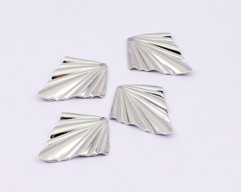 May include: Four silver metal fan-shaped charms with a textured surface.