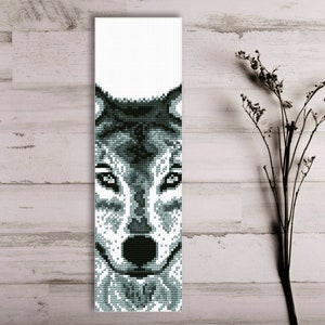 Puede incluir: Un primer plano en blanco y negro de la cara de un lobo. El pelaje del lobo está detallado con un diseño pixelado.