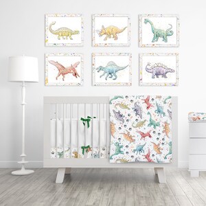 May include: A nursery set featuring dinosaur-themed artwork and bedding. The set includes framed watercolor prints of various dinosaurs, a crib bumper, a blanket, and a changing pad cover. The color palette includes shades of blue, green, yellow, and pink.