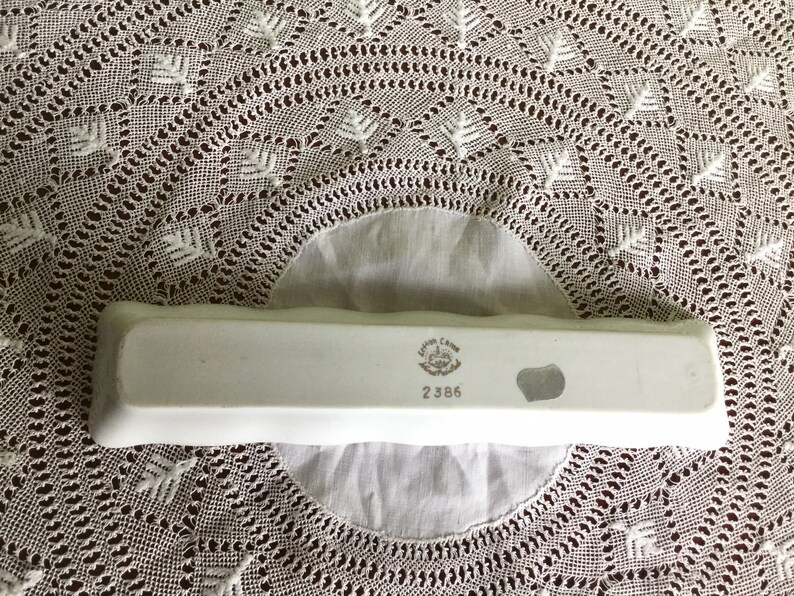 May include: White rectangular ceramic dish with a raised edge. The bottom of the dish has a printed mark that reads "Irish Charm" and "2386".