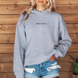 May include: A gray hooded sweatshirt with the text "faith over fear" printed on the front.