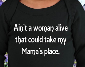 Puede incluir: Mono negro de manga larga con texto blanco que dice "Ain't a woman alive that could take my Mama's place." El mono lo lleva un bebé.
