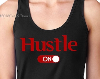 May include: Black tank top with the text "Hustle ON" in red lettering. The word "Hustle" is in a large, bold font, and the "ON" is in a smaller font and is next to a red circle with a white dot inside, representing a switch.
