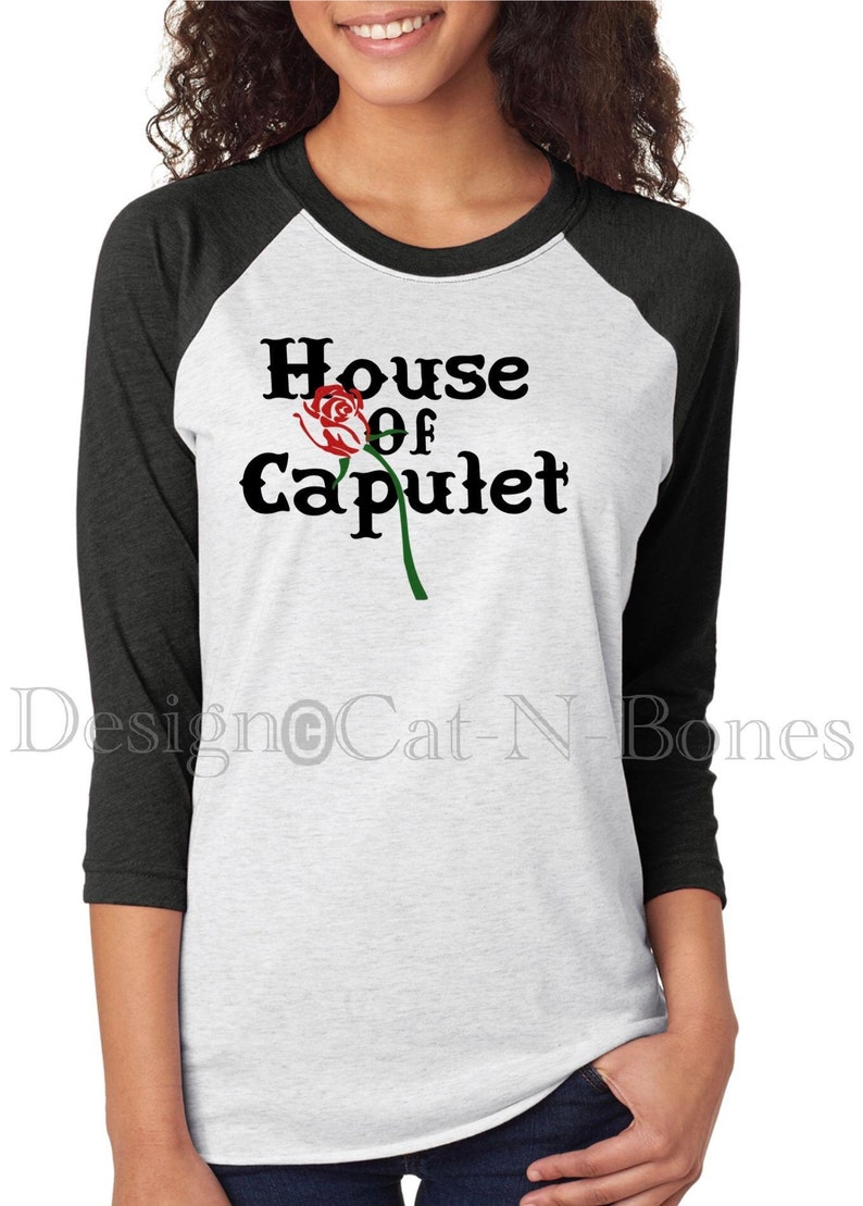 May include: A white and black baseball tee shirt with the text "House of Capulet" and a red rose graphic.