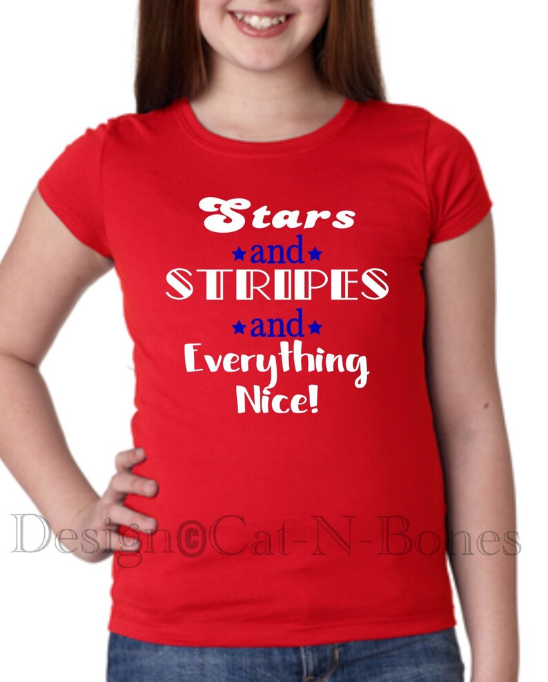 May include: Red t-shirt with white text that reads "Stars and Stripes and Everything Nice!"