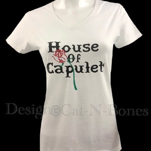 May include: White t-shirt with a black graphic that says "House of Capulet" with a red rose and green stem.