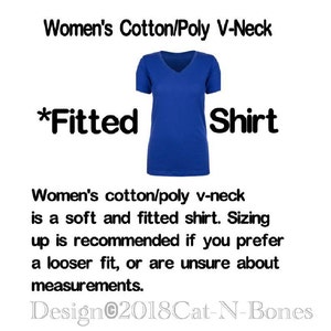 May include: A blue fitted v-neck shirt made of cotton and polyester. The shirt is described as *Fitted* and the text *Women's Cotton/Poly V-Neck Shirt* is displayed above the shirt. The text *Design&copy;2018Cat-N-Bones* is displayed below the shirt. The text below the shirt also states that the shirt is soft and fitted and that sizing up is recommended if you prefer a looser fit or are unsure about measurements.