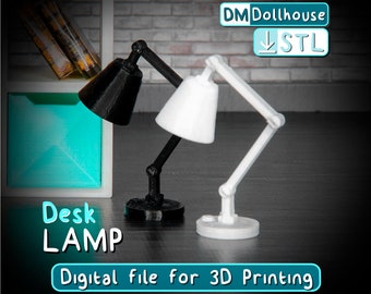 May include: Two 3D printed desk lamps, one black and one white, with adjustable arms and shades. The lamps are on a dark surface with a shelf and drawers in the background. The text "Desk LAMP" and "Digital file for 3D Printing" is visible below the lamps.