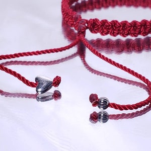 Puede incluir: Pulsera de cord&oacute;n trenzado rojo con abalorios de coraz&oacute;n y cuentas plateadas. La pulsera es ajustable con un nudo deslizante.