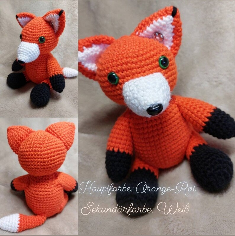 May include: A crocheted orange-red fox plush toy with white accents on the face and tail. The fox has black paws and green eyes. The text "Hauptfarbe: Orange-Rot Sekund&auml;rfarbe: Wei&szlig;" is visible in the image.