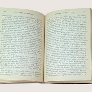 May include: Open book pages with text, featuring the title "THE QUEEN OF THE AIR" and "ATHENA IN THE EARTH." The pages are aged, with text in a classic serif font. The book is open, revealing the text and the binding.