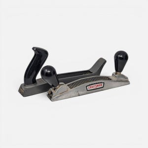 May include: Two metal hand planes for woodworking. One tool is a black block plane with a curved handle. The other is a silver Craftsman surform plane featuring a perforated metal blade, a black knob handle, and the brand name printed in red.