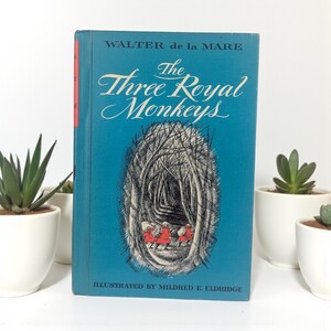 May include: A vintage hardcover book titled "The Three Royal Monkeys" by Walter de la Mare. The book has a teal cover with white text and an illustration of a forest scene with three figures in red. Illustrated by Mildred E. Eldridge.