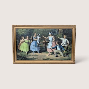 Puede incluir: Impresión vintage enmarcada que representa a un grupo de niños jugando al aire libre. La obra de arte presenta a una niña con los ojos vendados, niños con vestidos y un perro pequeño. El marco dorado y rectangular añade un toque clásico a la escena.