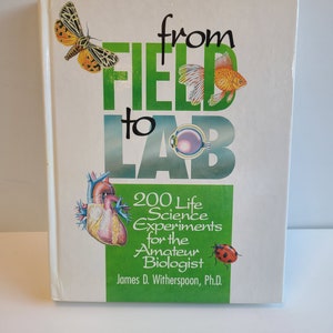 May include: A book titled "From Field to Lab: 200 Life Science Experiments for the Amateur Biologist" by James D. Witherspoon, Ph.D. The cover features a green background with illustrations of a butterfly, a goldfish, an eye, a heart, and a ladybug.