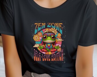 May include: Black t-shirt with a graphic of a cartoon frog meditating in a flower field. The text "Zen Zone Self-Love Edition" is printed on the shirt.