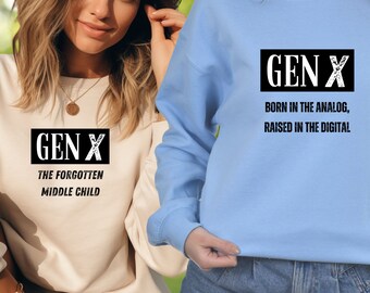 May include: Two sweatshirts with the text "GEN X" on them. One sweatshirt is light beige with the text "THE FORGOTTEN MIDDLE CHILD" below the logo. The other sweatshirt is light blue with the text "BORN IN THE ANALOG, RAISED IN THE DIGITAL" below the logo.