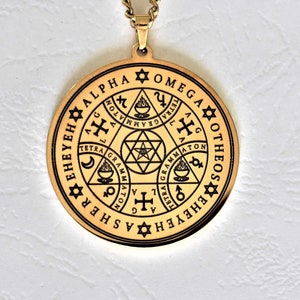 May include: Gold pendant necklace with a circular design featuring a star of David, a cross, and other symbols. The pendant is inscribed with the words "EHEYEH EHEYEH ASCHER SHEH ALPHA OTHEOS OMEGA".