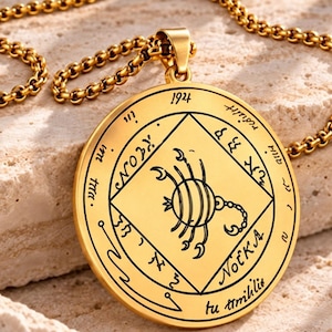 Peut inclure: Un pendentif circulaire doré avec une gravure noire représentant un scorpion à l'intérieur d'un losange. Le médaillon porte les inscriptions 1924, NOEKA, ainsi que divers symboles sur le pourtour, le tout suspendu à une chaîne dorée.