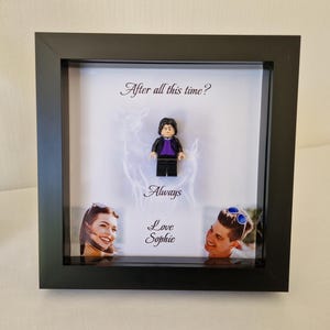 Może przedstawiać: Czarna ramka z cieniowaną ramką z figurką Lego, zdjęciem pary i tekstem "After all this time? Always Love Sophie".