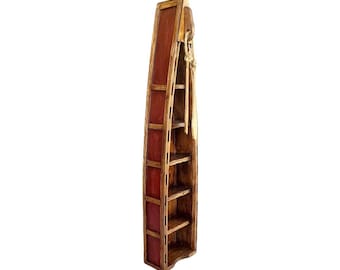 May include: A wooden bookshelf shaped like a boat with five shelves. The bookshelf is painted red and has a natural wood finish.