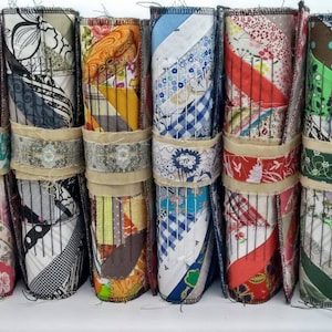 May include: Six colorful fabric-covered journals with wire binding. Each journal has a different pattern and color scheme, including red, blue, green, and brown.