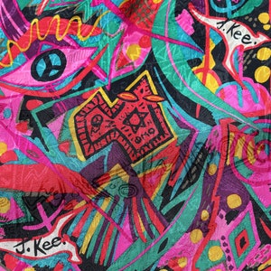 May include: A colourful abstract print fabric with a variety of shapes and designs, including a peace sign, a star, and the text "J. Kee."