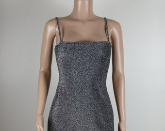 May include: A silver sparkly mini dress with thin straps and a square neckline.