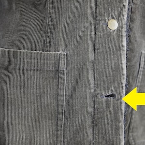 May include: A gray corduroy jacket with a button and a small hole near the bottom of the zipper.
