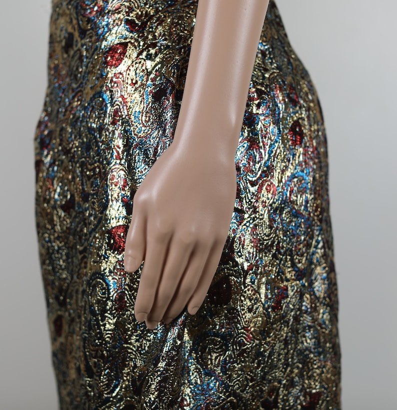 May include: A gold, blue, and red brocade skirt with a paisley pattern.