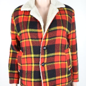 May include: A red, black and yellow plaid jacket with a white faux fur collar. The jacket has a button closure and two pockets.